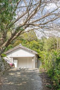 a small white garage with a tree in front of it at Komorebi no Yado - Vacation STAY 19011v in Goto