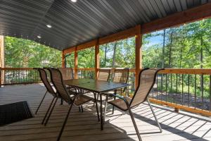 a table and chairs on a screened in porch at Peaceful Timbers Getaway in Hollister