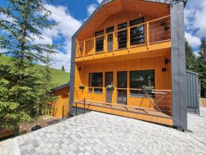 a house with a large deck on the front of it at Savanna Mountain forest resort in Yablunytsya
