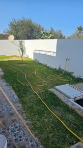 a house with a lawn with yellow hose at Private Family Villa with Pool Garden and Parking spot 3BR 2BA in Al Maqārisah