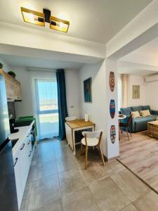 a kitchen and living room with a table and a couch at SeaTok & Stay in Costinesti