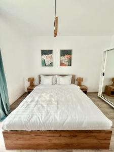 a bedroom with a large bed with white sheets at SeaTok & Stay in Costinesti