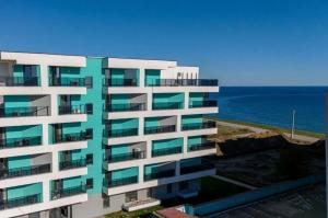 an apartment building with the ocean in the background at SeaTok & Stay in Costinesti