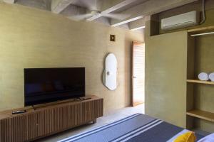 a bedroom with a flat screen tv on a wall at Casa Palmeras 1 - Amazing Beach House in Brisas de Zicatela