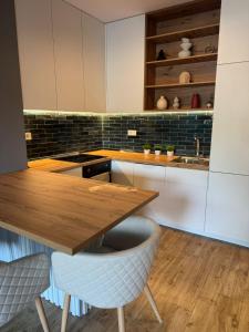 a kitchen with a wooden table and two chairs at AD Luxe Lake Suite in Ohrid