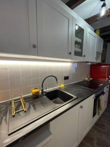 a kitchen with a sink and white cabinets at El Portalet de Can Rialla in Santa Pau +34 photos
