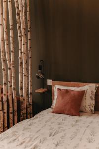 a bedroom with a bed with white sheets and trees at Crossroads Cabin in Sălişte