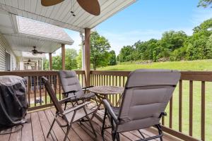 two chairs and a table on a deck with a view at Warm Welcome Getaway - Resort Stay for 6 in Branson