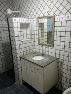 a bathroom with a sink and a mirror at Kitnet central in Franca