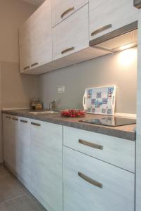 a kitchen with white cabinets and a sink at Apartments Masek in Poreč