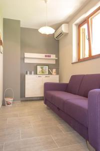 a living room with a purple couch and a kitchen at Apartments Masek in Poreč