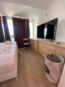 a bedroom with a bed and a flat screen tv at Apartments Ylona in Primošten