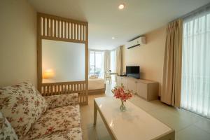 a living room with a couch and a table at Shamrock Hotel Pattaya in Pattaya South +49 photos
