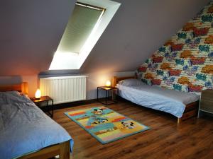 Zimmer im Dachgeschoss mit 2 Betten und einem Teppich in der Unterkunft Familijne Zacisze in Mienzebrosche