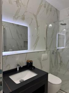 a bathroom with a sink and a toilet and a mirror at Rezidenca Mabel in Velipojë +71 photos