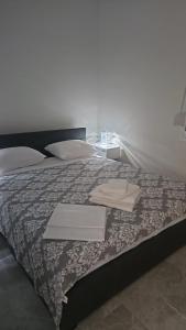 a bed with two towels on top of it at Fotis Apartments Palaiokomi in Palaiokómi