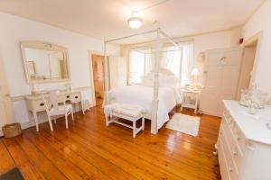 a bedroom with a bed and a desk and a mirror at The Cottage House in Thompson
