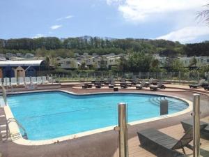 a large swimming pool with lounge chairs at Golden Sands Getaways Weymouth in Wyke Regis