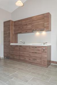 a large kitchen with wooden cabinets and a tile floor at Apartments Masek in Poreč +58 photos