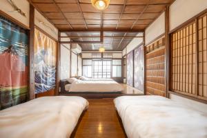 贝冢市Sanada Maru - Fully rented traditional Japanese house的有两张床和一扇窗户的房间