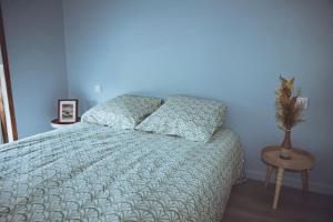 a bedroom with a bed with a blue wall at Grange Les Sens Ciel in Saint-Mesmin