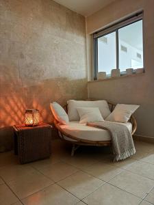 a couch sitting in a room with a window at Sea Breeze - Modern Marina Stay in Ashdod