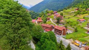 a village in the mountains with a road and a truck at Meric Hotel in Uzungöl