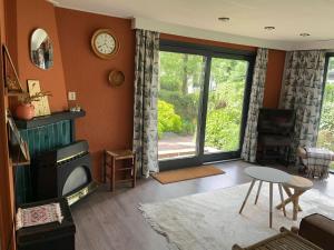 a living room with a tv and a large window at Relax Chalet Veluwe in Putten