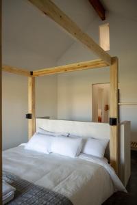 a bedroom with a large bed with white pillows at Hotel El Aguamiel in Lunlunta