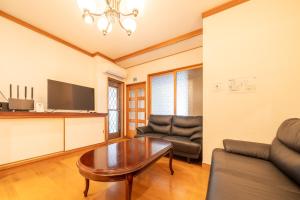 a living room with a couch and a table at Sanada Maru - Entire traditional Japanese house in Kaizuka