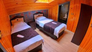 a small room with two beds and a mirror at Meric Hotel in Uzungöl