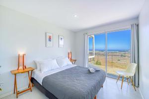 ein Schlafzimmer mit einem Bett und einem großen Fenster in der Unterkunft Oasis de Tunquen - Increible Vista y Hot Tub in Tunquen + 33 Fotos