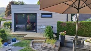a patio with an umbrella and a house at Chez Matt et Jo in Lautenbachzell