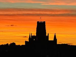 a silhouette of a building with a sunset in the background at Private Bedroom in a Shared Penhouse in Gilesgate