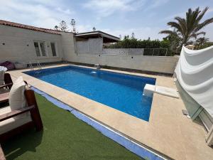 a swimming pool in front of a house at Beach House - Ramsis Village in ‘Izbat aţ Ţayrīyah