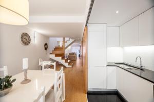 a kitchen and dining room with white cabinets at Modern 2-bedroom apartment in the Historic Center in Braga