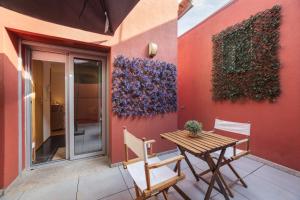 a patio with a table and chairs next to a wall at Modern 2-bedroom apartment in the Historic Center in Braga