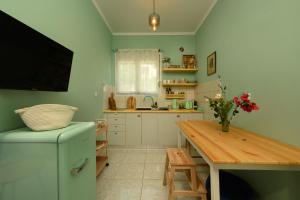 a kitchen with a refrigerator and a table and a television at Zoe City Home in Corfu