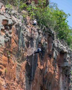 two people on a rappelling line on a cliff at Rota Mundus Turismo e Hospedagem in Botucatu +10 photos