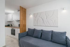 a living room with a blue couch and a kitchen at CASA ANNA BOUTIQUE SUITE Apartment New in Adamas