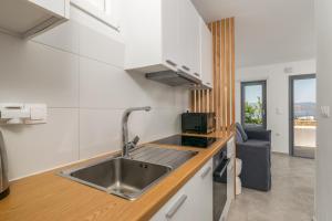 a kitchen with a sink and a counter top at CASA ANNA BOUTIQUE SUITE Apartment New in Adamas +20 photos