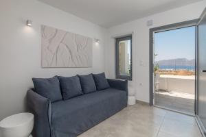 a living room with a blue couch and a window at CASA ANNA BOUTIQUE SUITE Apartment New in Adamas
