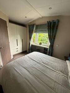 New HunstantonにあるModern 6 birth caravan Hunstanton Norfolkの大きなベッドと窓のある寝室