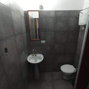 a small bathroom with a toilet and a sink at Complejo Corrientes Depto 4 in Jesús María