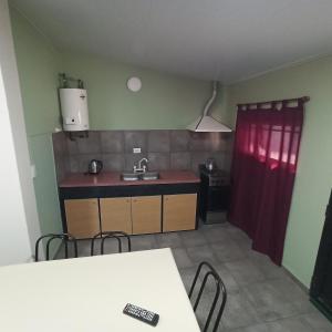 a kitchen with a table and chairs in a room at Complejo Corrientes Depto 4 in Jesús María