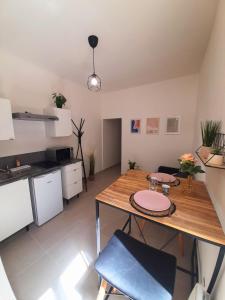 une cuisine et une salle à manger avec une table et des chaises en bois dans l'établissement Le Refuge de l'Écusson - T2 centre-ville, WIFI, à Montpellier 6 autres photos