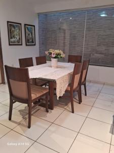 a dining room table with chairs and a vase with flowers on it at Aconchego do sertão in Petrolina +4 photos