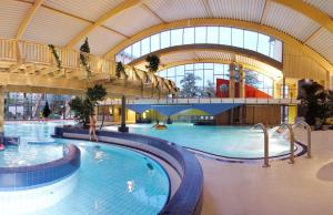 une grande piscine intérieure dans un bâtiment dans l'établissement Hasseröder Ferienpark, à Wernigerode