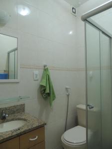 y baño con aseo, lavabo y espejo. en Apartamento Copacabana, en Río de Janeiro