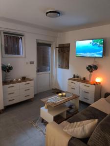 a living room with a couch and a tv on the wall at Mieszkanie do wynajęcia w Centrum in Olecko